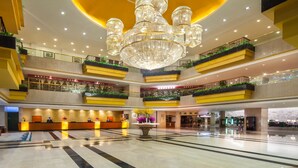 A multi-level hotel lobby with a grand chandelier, multiple balconies, and a reception desk. - Kunming Jin Jiang Hotel (Kunming)