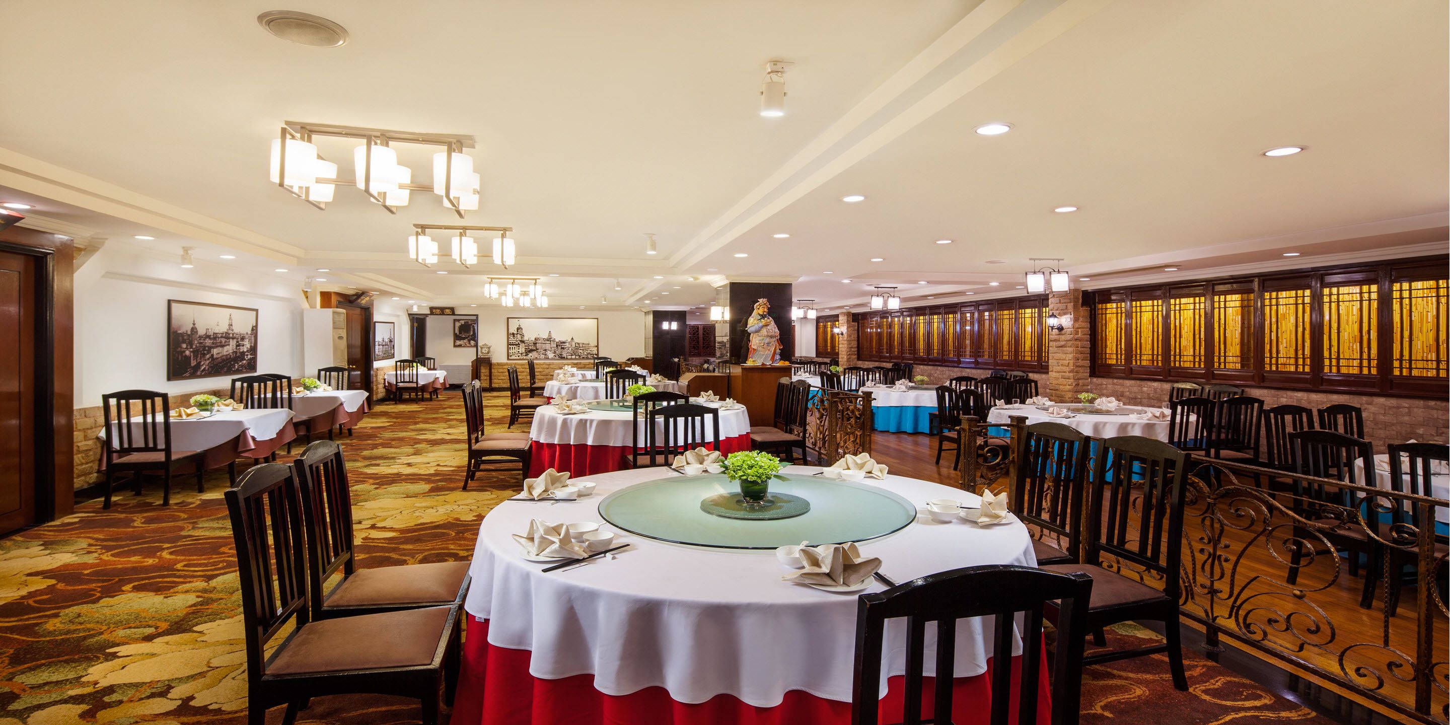 A spacious dining area with round tables, chairs, and a decorative centerpiece.
