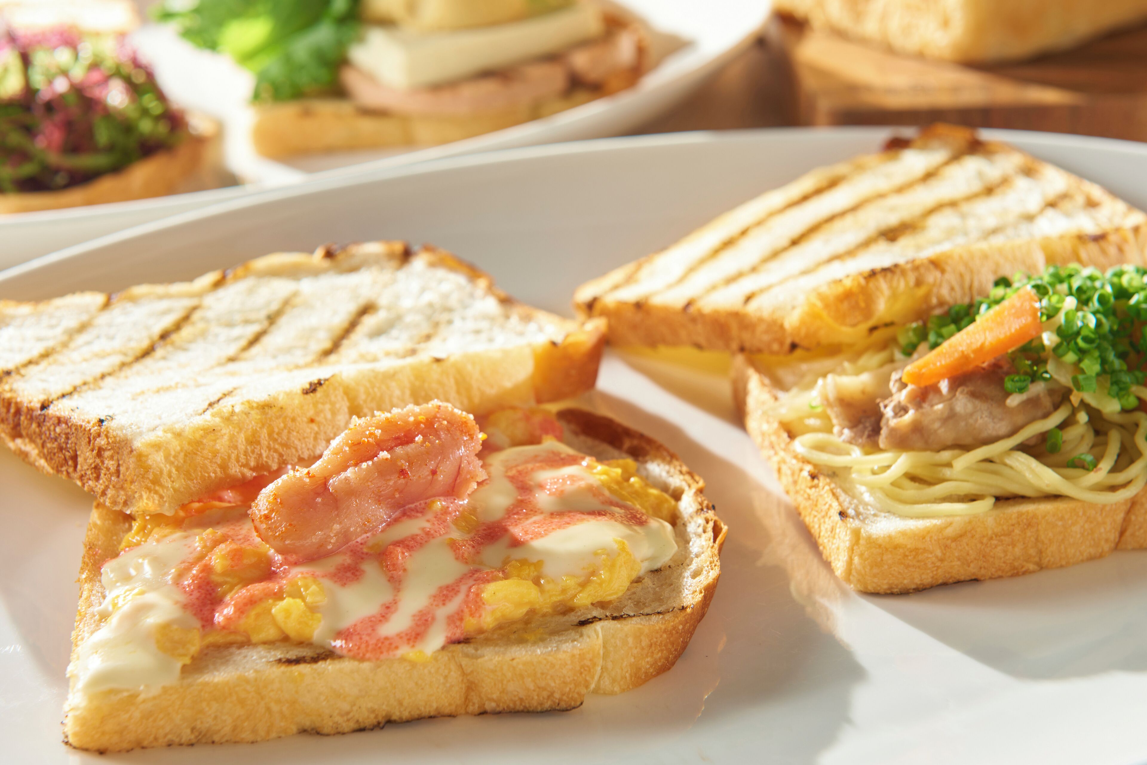 A plate with three sandwiches, each with different fillings.