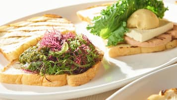 A plate with three types of sandwiches: one with greens, one with a meat topping, and one with a cheese and mushroom.