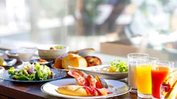 A breakfast table with various dishes, including eggs, bacon, and toast, along with glasses of orange juice.