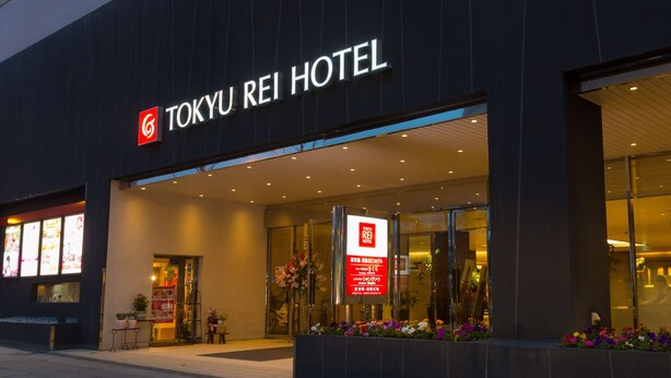 El exterior del Hotel Tokyo Rei, con una fachada moderna, puertas de entrada amplias y un letrero de hotel visible.