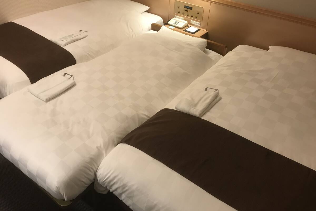 Driepersoonskamer, niet-roken (2 Single Beds+ Extra Bed, 18sqm) | Donsdekens, een kluis op de kamer, een bureau, verduisterende gordijnen
