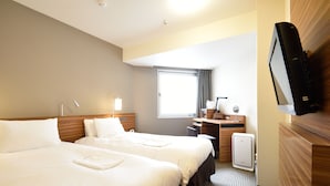 Une chambre d’hôtel avec deux lits, un bureau, une télévision et une fenêtre avec des rideaux.