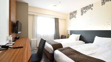 A hotel room with two beds, a desk, a chair, a television, and a window with curtains.