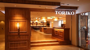 A hotel lobby with wooden paneling, a reception desk, and a sign for 'Toriko Fine Dining & Lounge'. - Kobe Sannomiya Tokyu REI Hotel (Kobe)