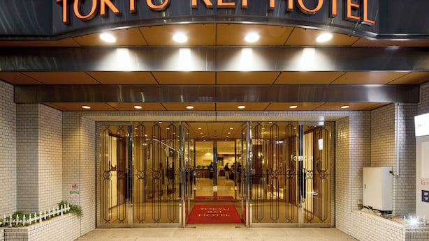 The entrance to the Tokyo Rei Hotel with a glass door and a red carpet leading inside. - Kobe Sannomiya Tokyu REI Hotel (Kobe)
