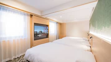 Habitación de hotel con una cama grande, televisión y vistas a un edificio tradicional.