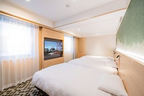 Een hotelkamer met een groot bed, een televisie en uitzicht op een traditioneel gebouw.