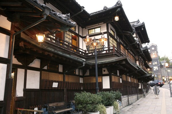 A traditional Japanese building with wooden architecture, multiple balconies, and hanging lanterns. - Matsuyama Tokyu REI Hotel (Matsuyama)