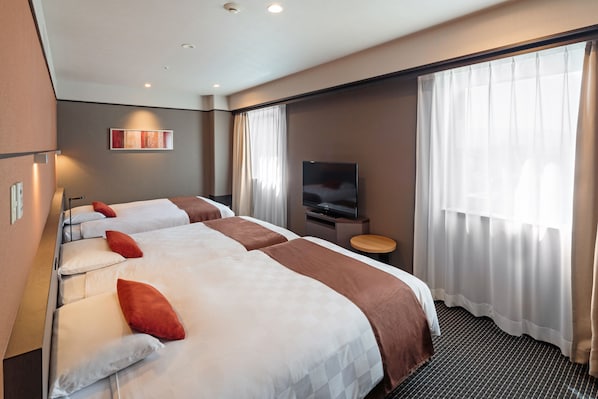 A hotel room with two beds, a TV, and a window with curtains. - Matsuyama Tokyu REI Hotel (Matsuyama)