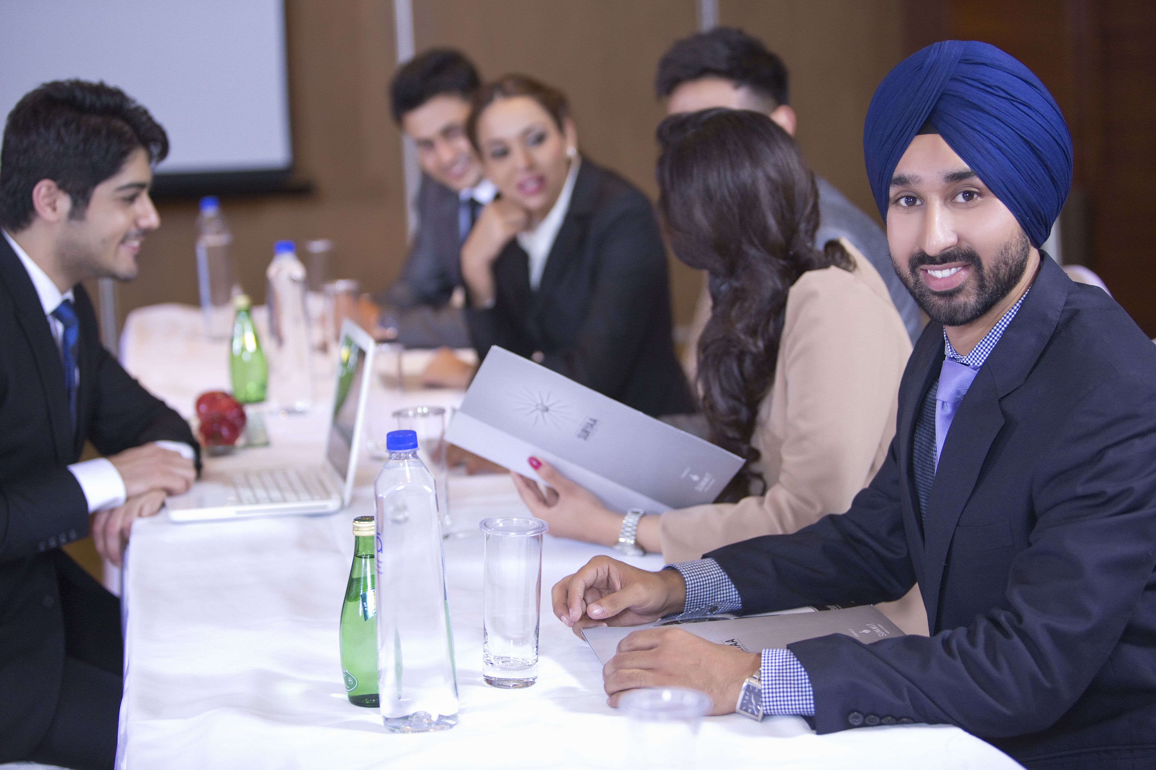 A conference room with a long table, laptops, and water bottles.