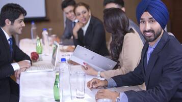 A conference room with a long table, laptops, and water bottles.