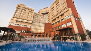 Un hotel con piscina, diversi piani e un evidente cartello con la scritta 'SURYA'.
