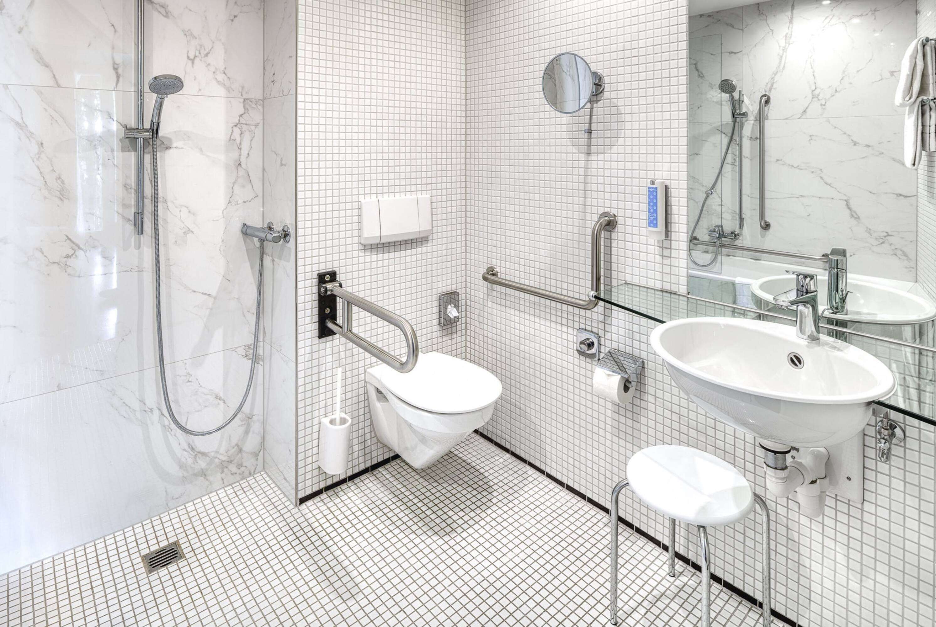 A modern bathroom with a glass-enclosed shower, a white sink, and a mirror.
