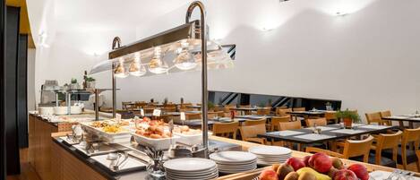 A buffet setup with various food items and utensils.
