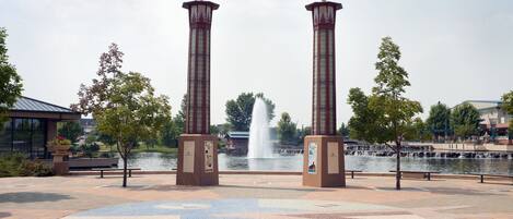 A park with two tall columns, a fountain, and a patterned walkway.