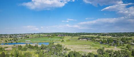 A golf course with a lake, surrounded by trees and residential areas.
