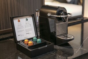 A Nespresso coffee machine with a menu stand beside it, displaying various coffee options.