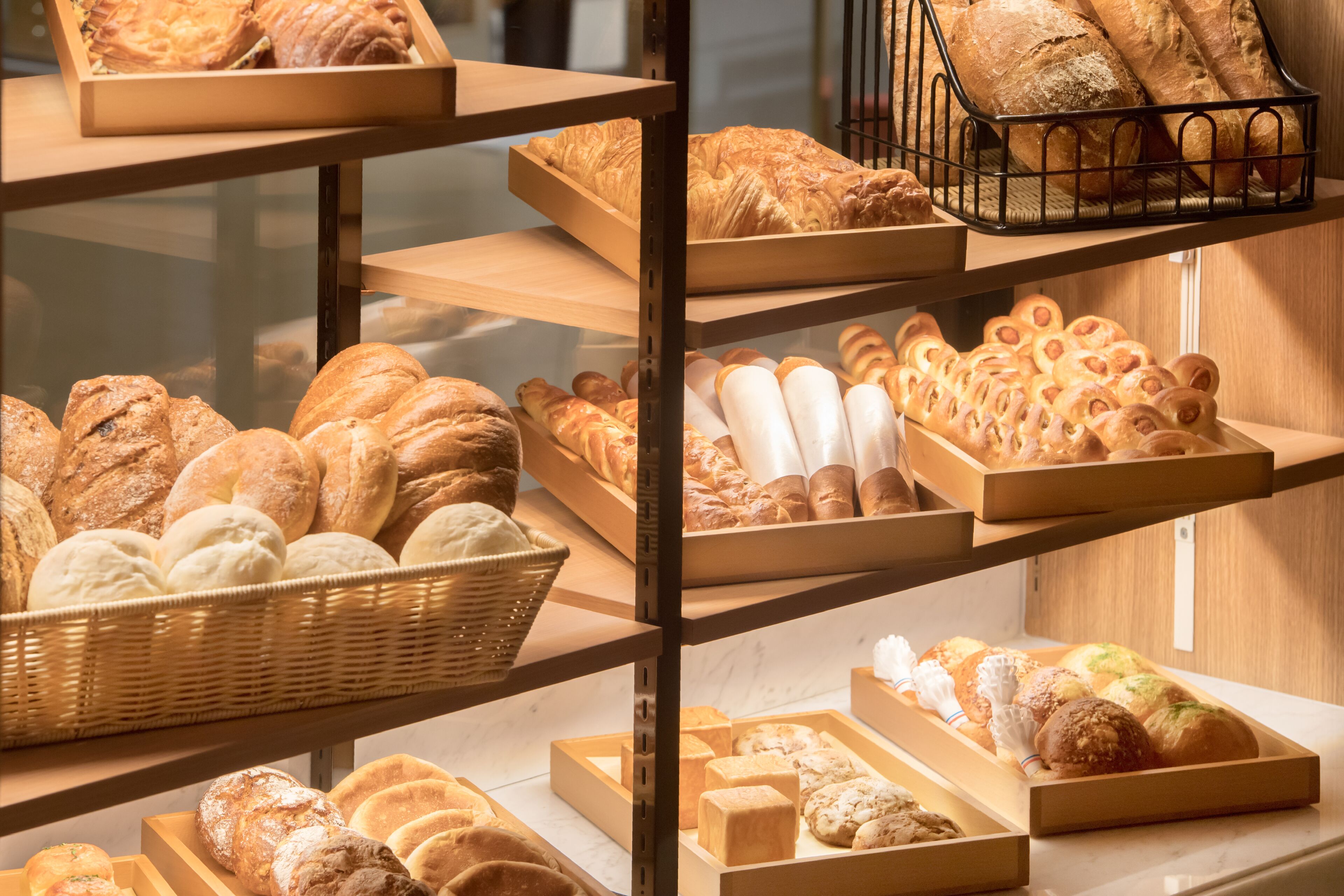 A bakery display with various types of bread and pastries.
