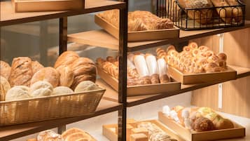A bakery display with various types of bread and pastries.