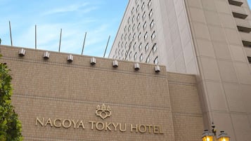 Exterior do Hotel Nagoya Tokyo, com design moderno, entrada destacada e céu claro.