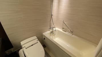 A modern bathroom with a toilet, a bathtub, and a shower.