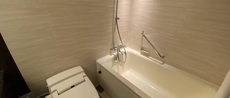 A modern bathroom with a toilet, a bathtub, and a shower.