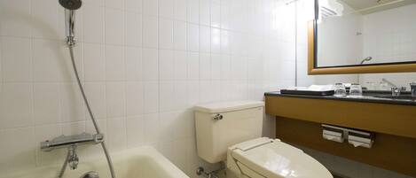 A bathroom with a bathtub, toilet, and a mirror above the sink.