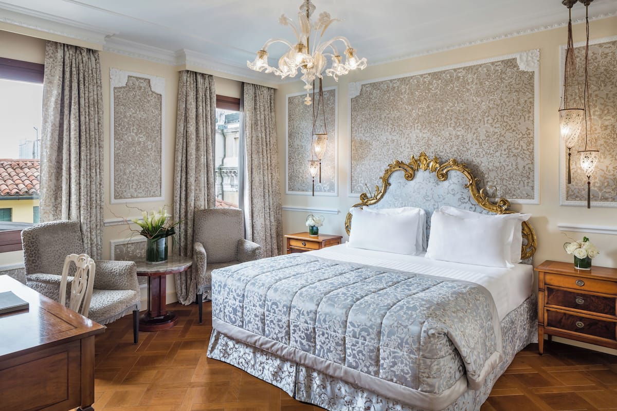Une chambre à coucher avec un grand lit, un lustre et une vue sur la ville.
