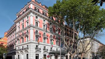 Un edificio de varios pisos con estilo arquitectónico clásico, que cuenta con balcones y una entrada destacada.