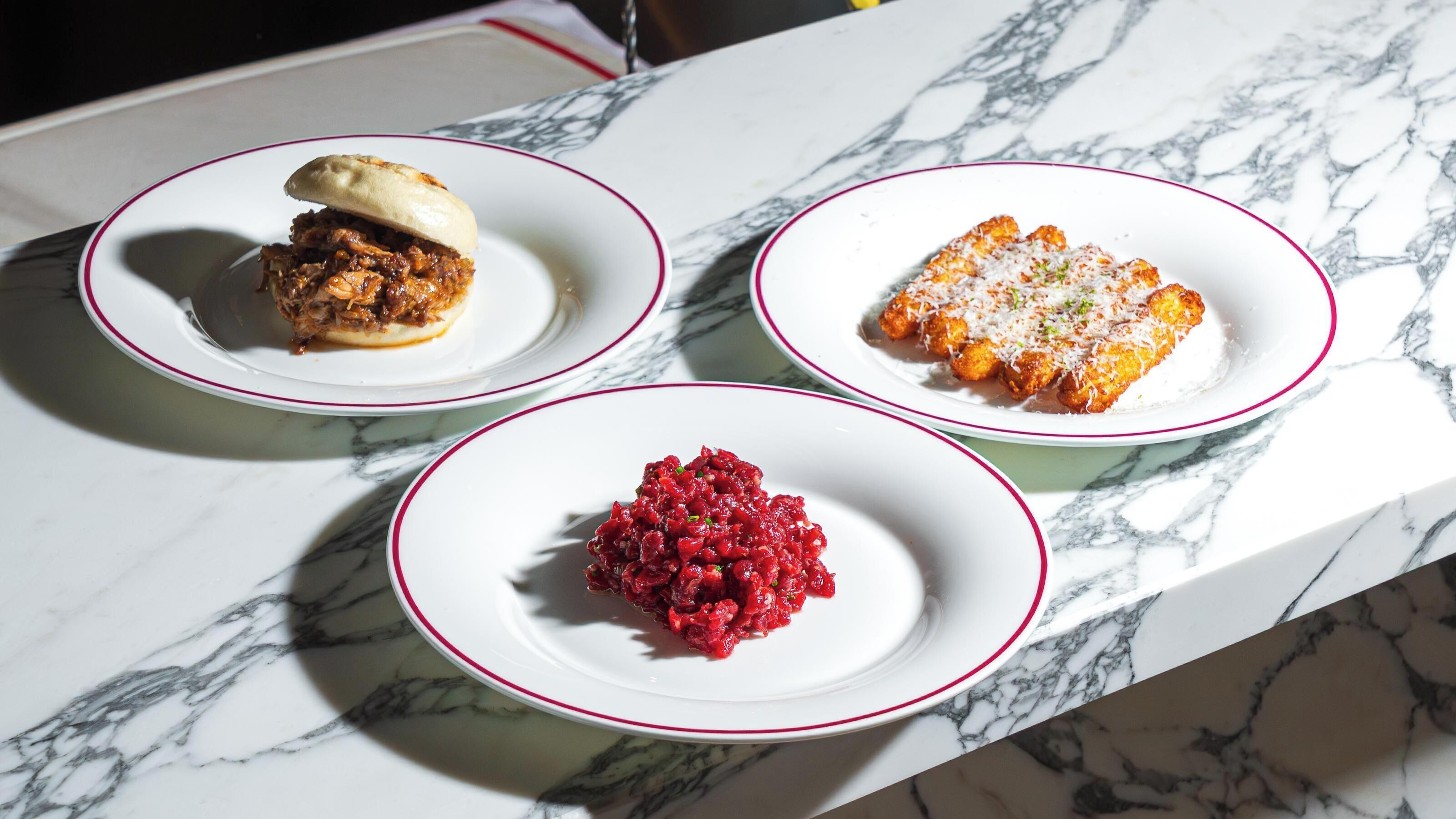Three dishes on a marble table.