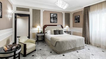 Une chambre d’hôtel avec un grand lit, une chaise, une petite table et deux tables de chevet avec des lampes.