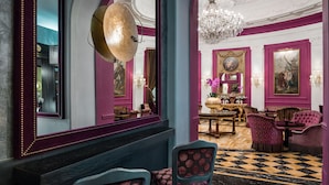 A grand lobby with a checkered floor, elegant furniture, and a chandelier. - Baglioni Hotel Regina - The Leading Hotels of the World (Rome)