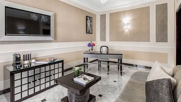 Una sala de estar moderna con un televisor de pantalla plana, una mesa de comedor y un sofá.