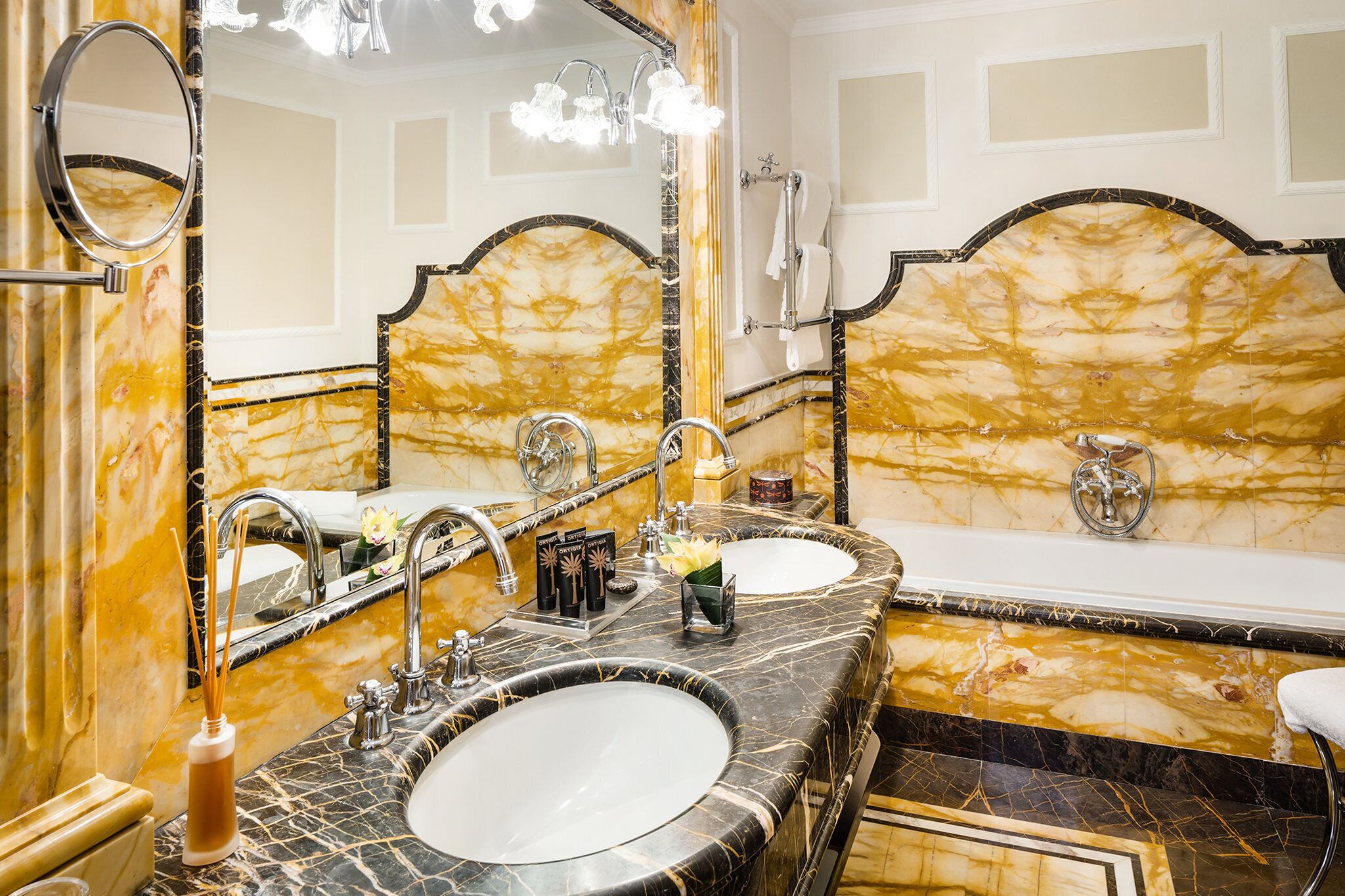 Une salle de bain luxueuse avec deux vasques, des comptoirs en marbre et un grand miroir.