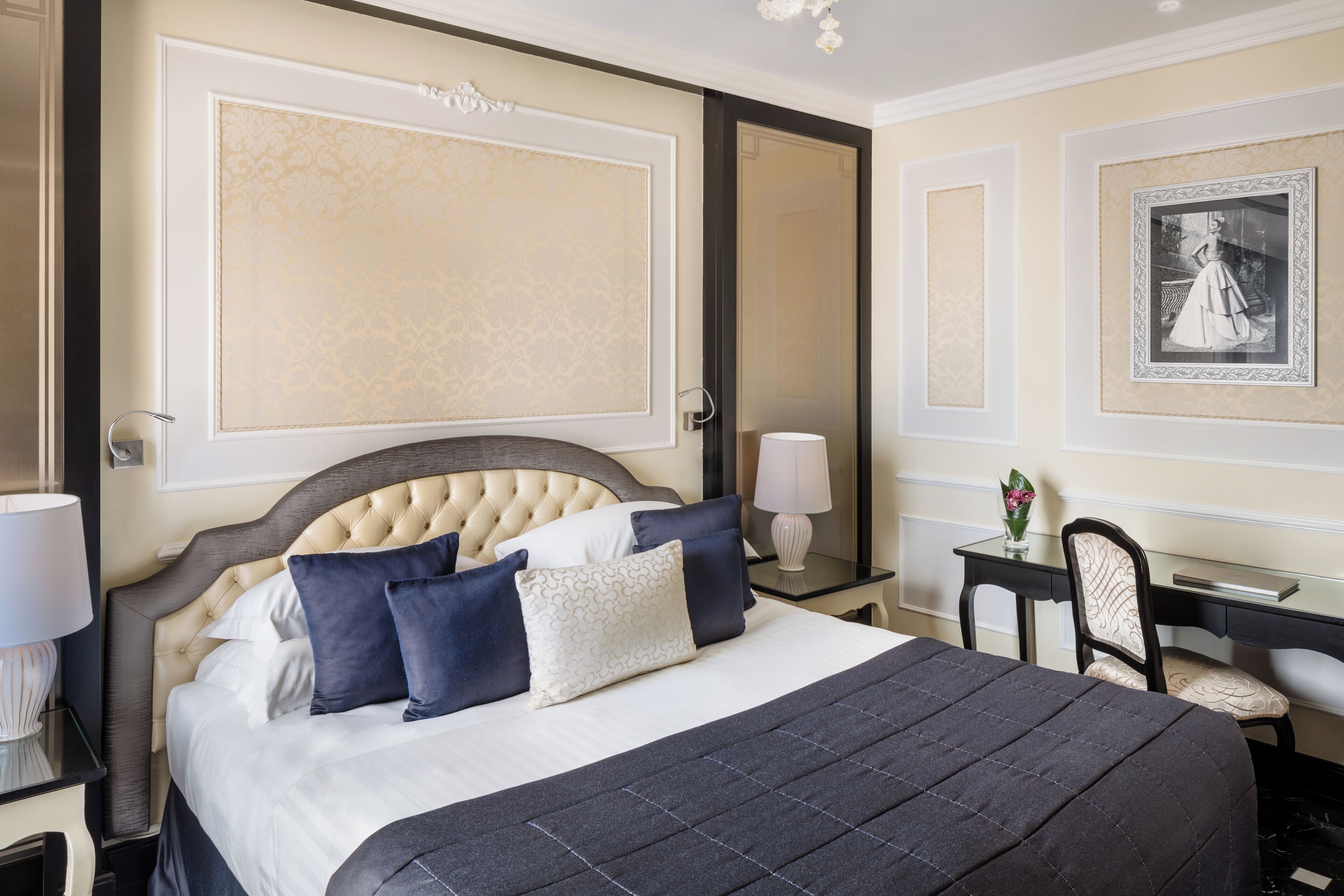 Une chambre d’hôtel avec un grand lit, un bureau, une chaise et un miroir.