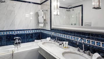 A bathroom with two sinks, a bathtub, and a large mirror.