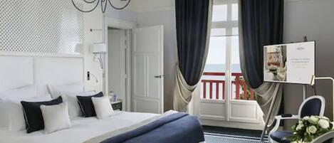 Une chambre d’hôtel avec un lit, une chaise, un bureau et une vue sur l’extérieur.
