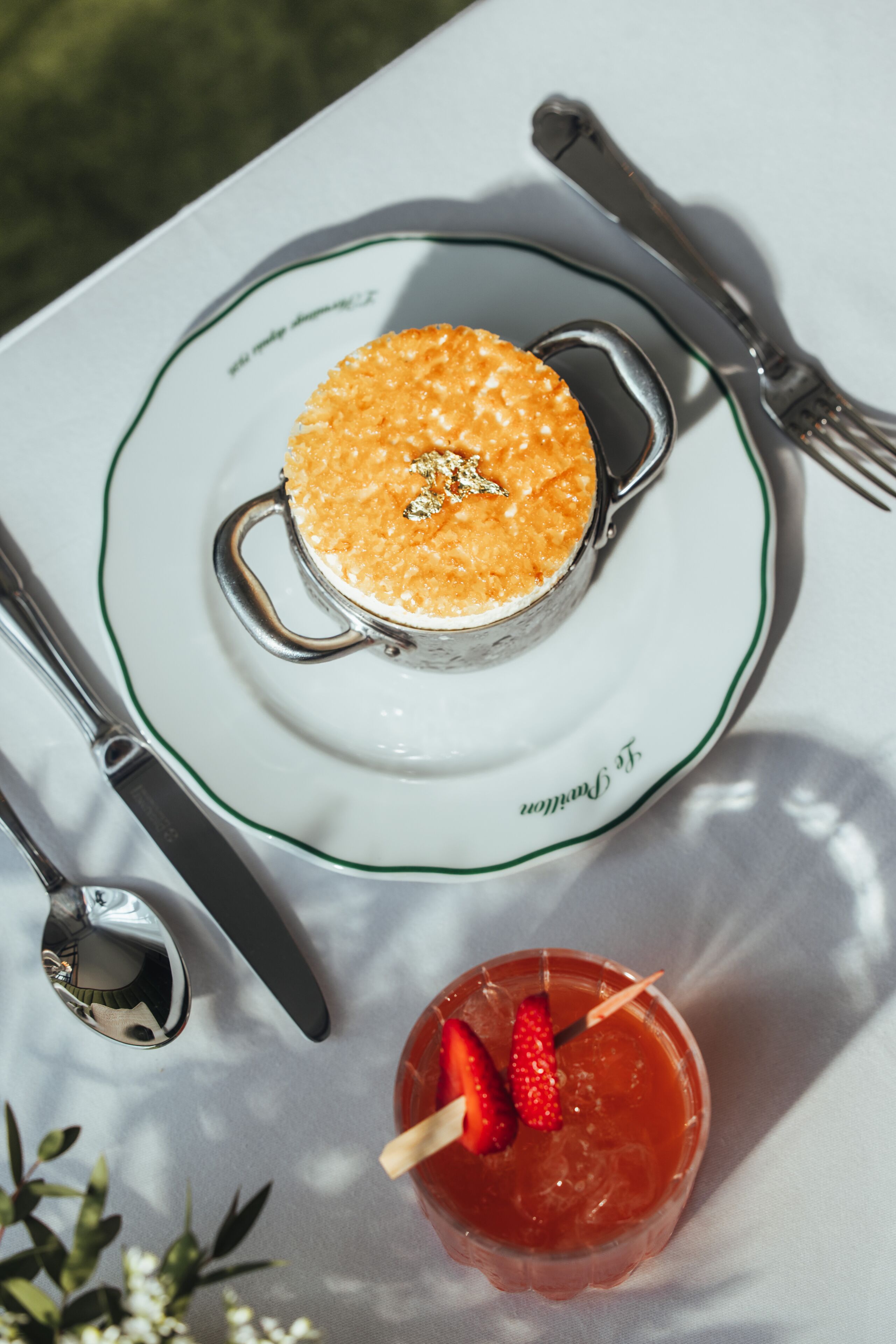 Un postre en un plato, con cuchara y tenedor a un lado.
