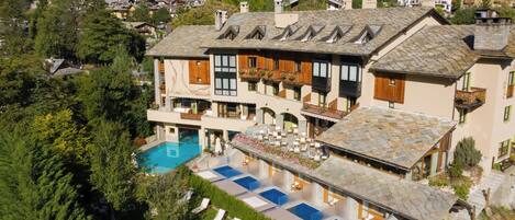 A large building with a swimming pool and multiple balconies.