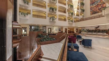 A spacious lobby with multiple levels, marble flooring, and modern furniture.