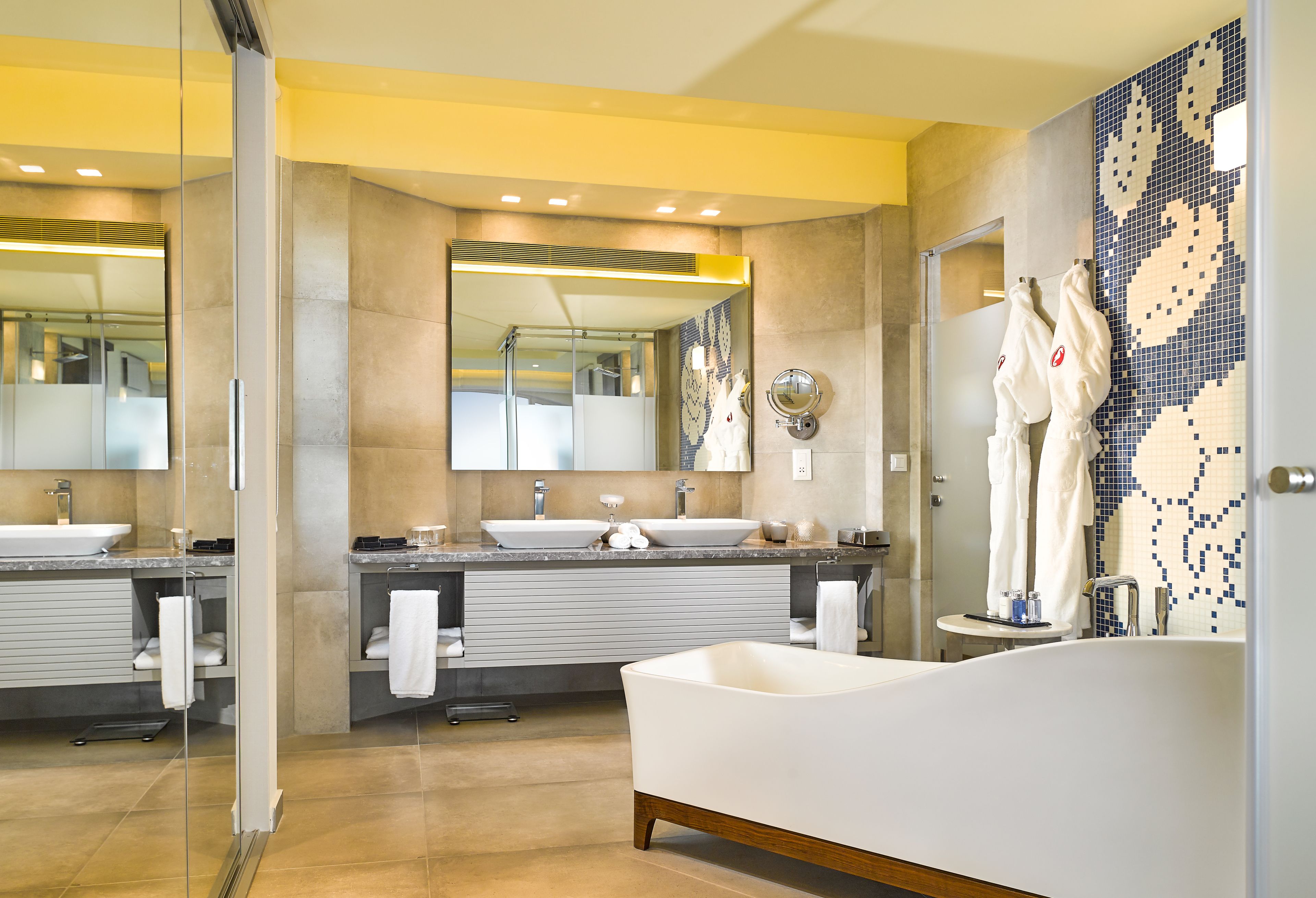 A modern bathroom with a freestanding bathtub, dual sinks, and a large mirror.