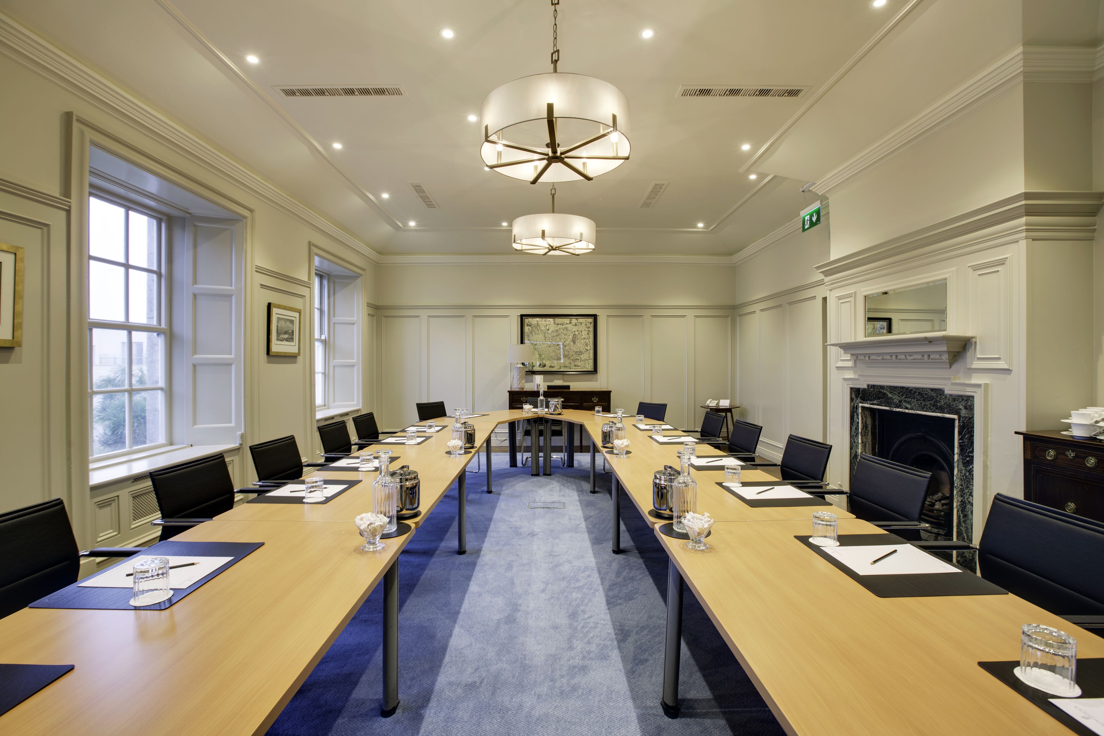A conference room with a long table, chairs, and a chandelier.