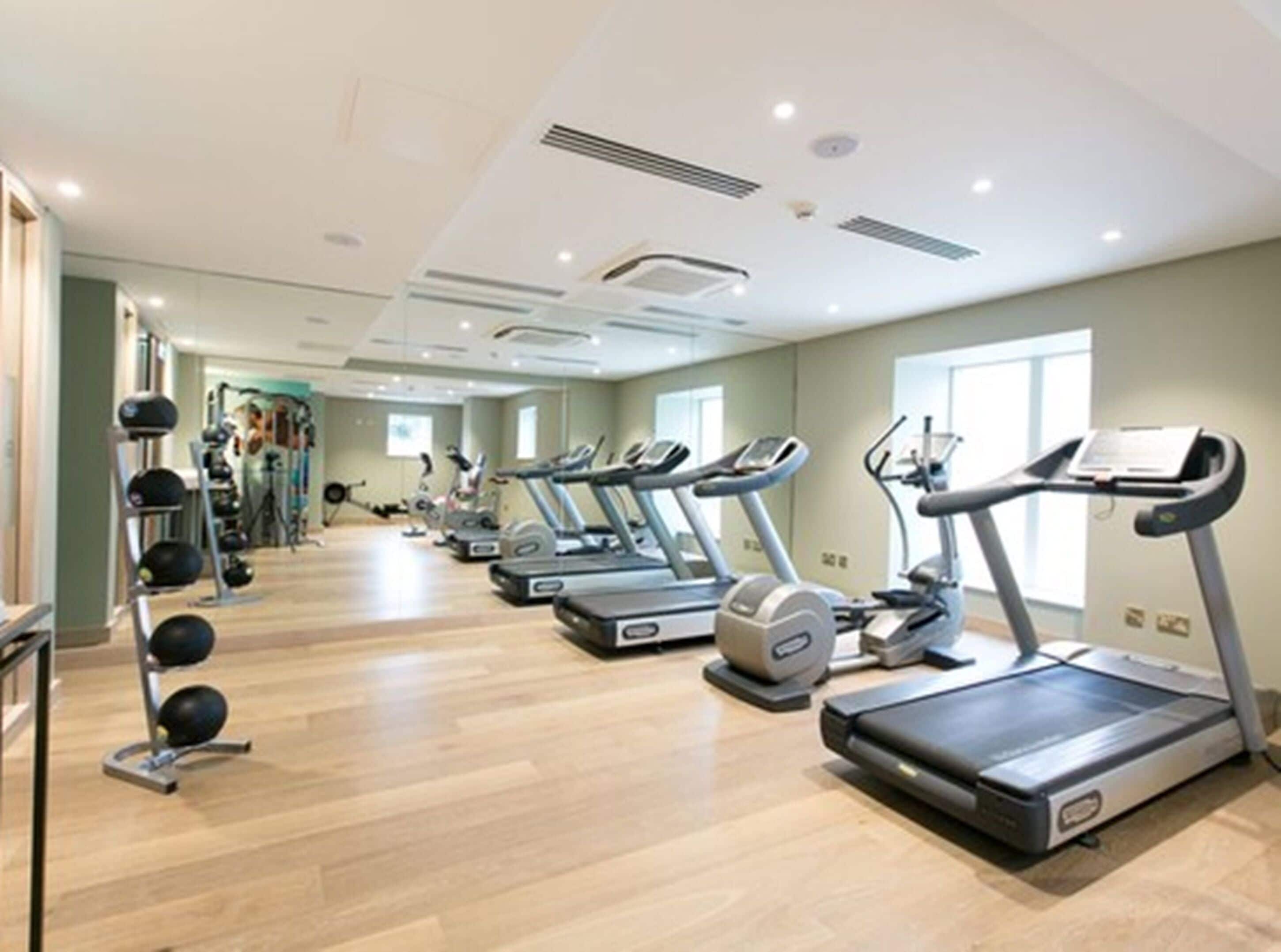 A gym with treadmills, stationary bikes, and weight machines.