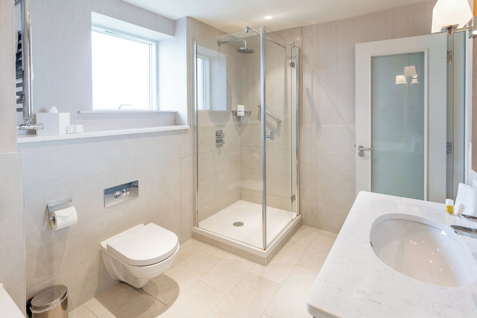Une salle de bain moderne avec une douche à parois de verre, des toilettes et un lavabo.