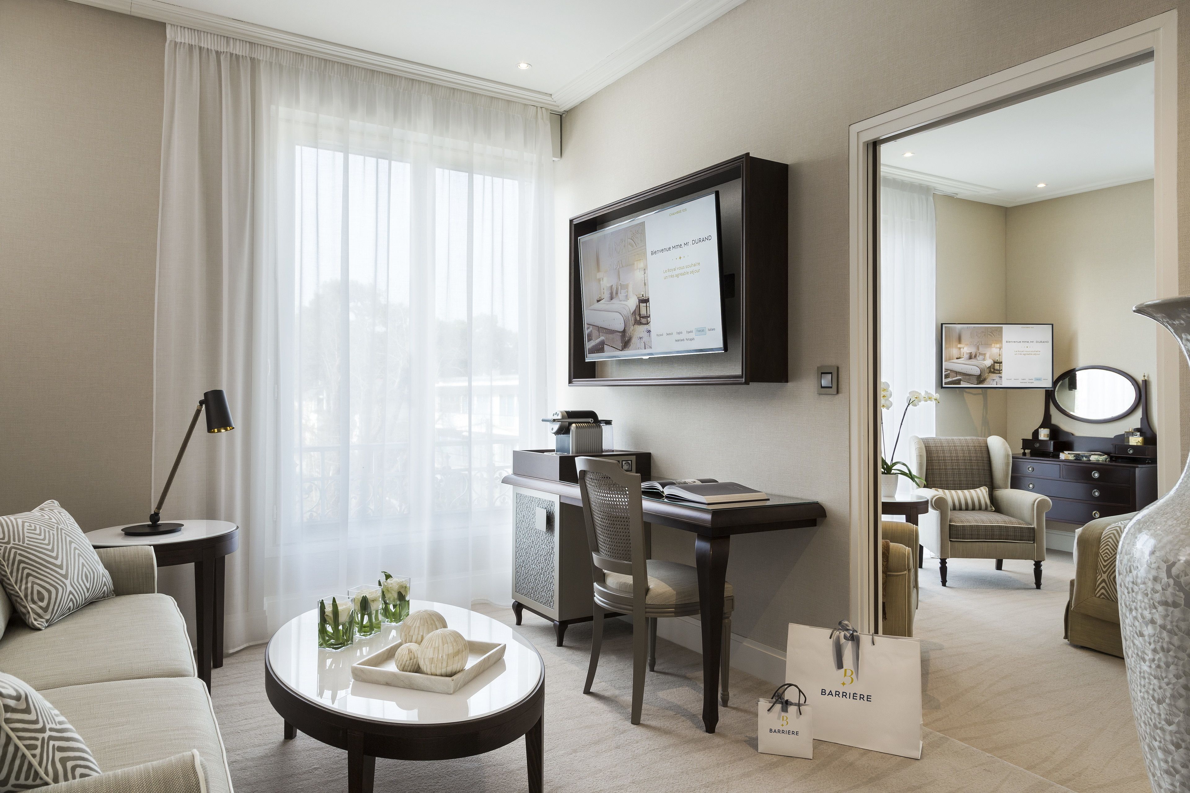 Une chambre d’hôtel comprenant un lit, un bureau, une chaise, une table basse et un téléviseur.