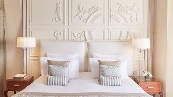 A hotel room with a large bed, two nightstands, and a decorative headboard.