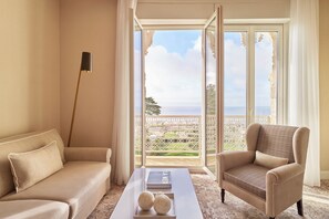 Suite Deluxe, 1 cama matrimonial, vista al mar | Área de sala de estar | Televisión de pantalla plana de 97 cm con canales por cable