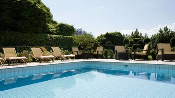 Una piscina al aire libre de temporada, sombrillas